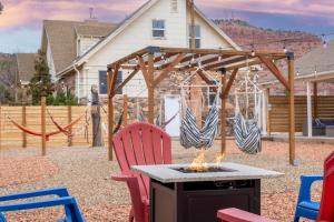 a patio with a fire pit with chairs and a swing at Adventure's Oasis, Venture Base Unit 4 in Kanab