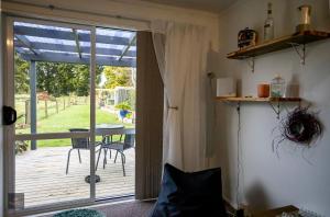 a room with a sliding glass door to a deck at Oak Lodge in Taheke