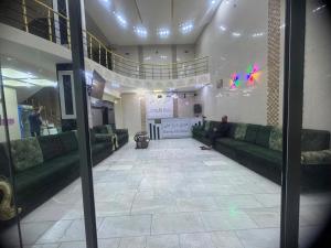 a man sitting on a couch in a lobby at فندق ومطعم درة علي in Qaryatal Karkāshīyah
