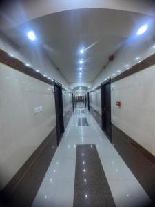 a hallway with doors and a long hallway with white walls at فندق ومطعم درة علي in Qaryatal Karkāshīyah