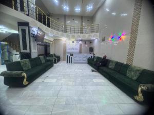 a man sitting on a couch in a lobby at فندق ومطعم درة علي in Qaryatal Karkāshīyah +2 photos
