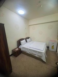 a bedroom with a bed with white sheets and a table at فندق ومطعم درة علي in Qaryatal Karkāshīyah