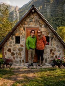 a man and woman standing in front of a house at Ebenezer Salkantay Huts in Colcapampa +2 photos