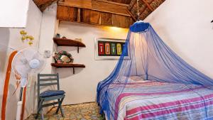 a bedroom with a bed with a mosquito net at El Árbol de la Vida in Bacalar