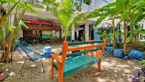 a wooden bench and a chair in a garden at El Árbol de la Vida in Bacalar
