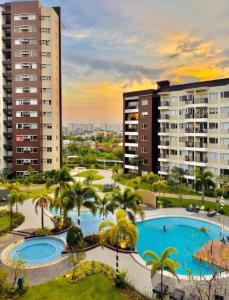 an apartment complex with two pools and palm trees at Avida Condo Lux Studio Unit in Iloilo City