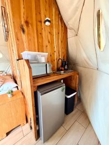 a kitchen in a tent with a small refrigerator at Green Noise Glamping in Fraijanes