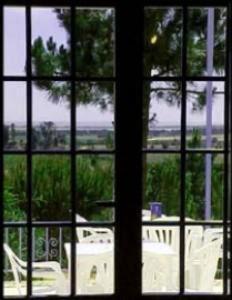 una ventana con vistas a un barco visto a través de ella en Hotel San Miguel en El Rompido