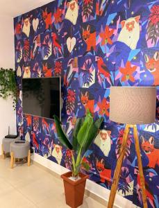 a living room with a blue wall with a cat wallpaper at Apartamento Centro Bertioga Casal e Família - Ar Condicionado - Praia da Enseada in Bertioga