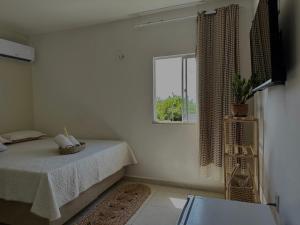 a white room with a bed and a window at Pousada Flor do Sol in Fortaleza