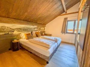 a bedroom with a large bed with a wooden ceiling at Auszeit am Afritzer See in Afritz