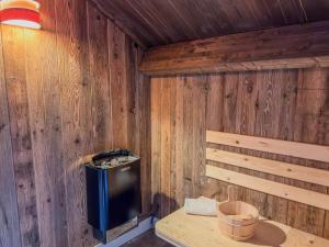 a room with a wood paneled wall with a small stove at Gerlitzen Seealm in Afritz