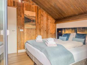 a bedroom with a large bed with wooden walls at Gerlitzen Seealm in Afritz