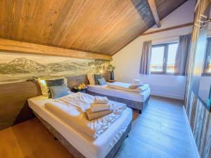 two beds in a room with wooden ceilings at am Afritzer See in Afritz