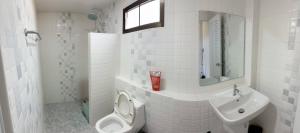 a white bathroom with a toilet and a sink at Tasowa House in Chiang Rai +15 photos