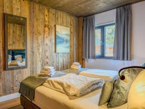 two beds in a room with wooden walls at Alpenchalet am See in Afritz