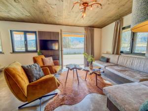 a living room with a couch and chairs and a table at Alpenchalet Kärntnerglück in Afritz
