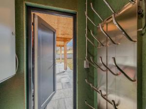 an open door in a green wall with antlers at Alpenchalet Kärntnerglück in Afritz +37 photos