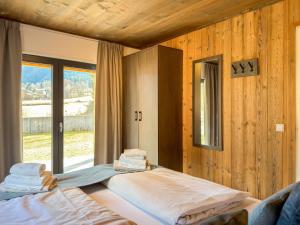 a room with two beds and a large window at Afritz am See in Afritz