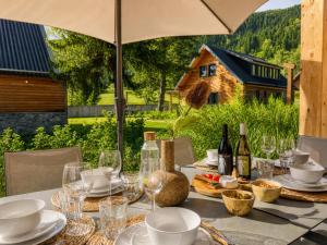 a table with wine glasses and wine bottles on it at Alpensehnsucht in Afritz