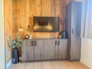 a television on top of a wooden cabinet in a room at Alpensehnsucht in Afritz