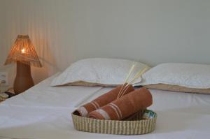 a basket of towels on a bed with a lamp at Pousada Flor do Sol in Fortaleza +22 photos