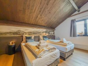 two beds in a room with a wooden ceiling at Alpenchalet Afritz am See in Afritz