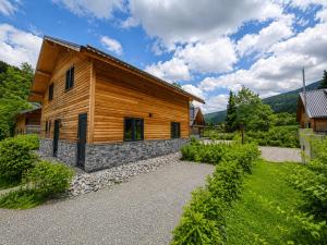 a log house with a stone walkway in front of it at Alpenchalet Afritz am See in Afritz