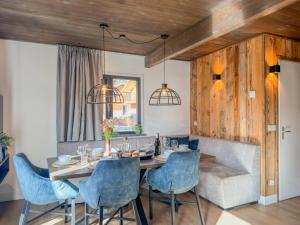 a dining room with a table and blue chairs at Seechalet Afritz in Afritz