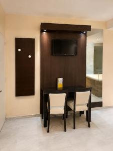 a dining room with a black table and chairs at Hotel Castelar suit in Castelar