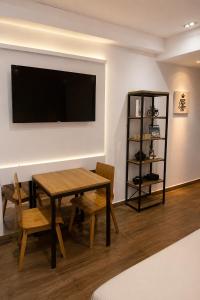 a dining room with a table and chairs and a tv at Hotel Castelar suit in Castelar