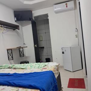 a small room with a bed and a refrigerator at Central in Juazeiro do Norte