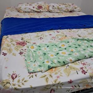 a bed with a floral comforter on it at Central in Juazeiro do Norte +2 photos