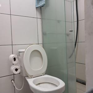 a bathroom with a toilet and a glass shower at Central in Juazeiro do Norte