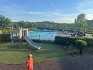a little girl standing in front of a swimming pool at Zicht op Valkenburg in Schin op Geul