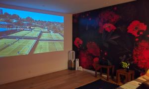 a room with a large window with a tennis court mural at Papillon 05 - Wellness - 6 Pers - Sauna - Jacuzzi - Yoga - Petanque - Parking in Briançon