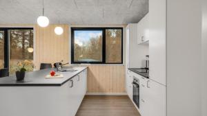 a kitchen with white cabinets and a large window at Villavilla 581 - Gjerrild, Østjylland in Grenå