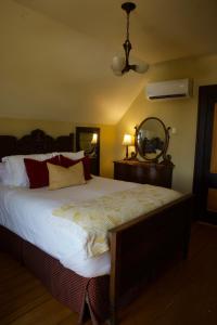 a bedroom with a large bed with white sheets at Magnetic Hill Winery in Moncton