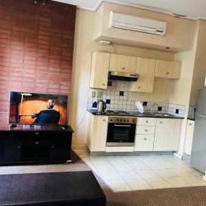 a kitchen with a picture of a man on the wall at Native Suites 411 in Johannesburg