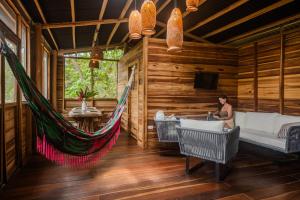 a woman sitting in a hammock in a cabin at La Casa Del Mono in Minca