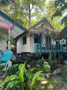 a small white house with a blue porch at Benny sweet family in Ao Phutsa