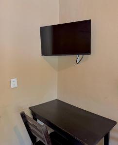 ein schwarzer Tisch mit einem Fernseher an der Wand in der Unterkunft Hotel Bacalar Sunshine in Bacalar