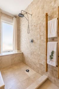 a bathroom with a tub and a shower with a window at Sunset Condo 104 Puerta al Mar Isla Mujeres Mexico in Isla Mujeres