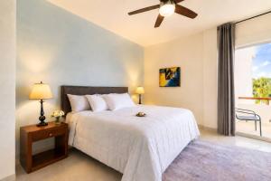a bedroom with a bed and a ceiling fan at Sunset Condo 104 Puerta al Mar Isla Mujeres Mexico in Isla Mujeres +26 photos
