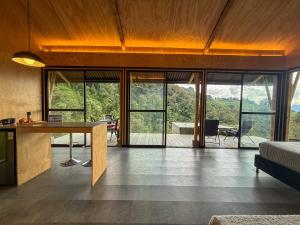 a bedroom with a desk and sliding glass doors at Glamping Bosque de helechos, privacidad y cercanía in Manizales