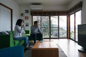 a man and woman sitting in a living room at Saka no Kaze in Onomichi +40 photos
