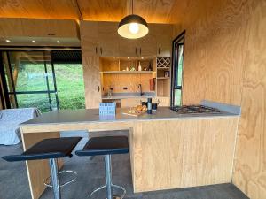 a kitchen with a counter and stools in a room at Glamping Bosque de helechos, privacidad y cercanía in Manizales
