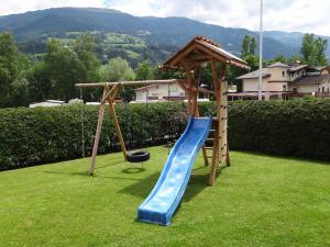 einen Spielplatz mit einer blauen Rutsche und einer Schaukel in der Unterkunft Ferienwohnung Schaffenrath in Kaltenbach
