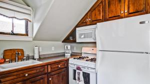 a kitchen with a white refrigerator and a sink at Hustons Attic by AvantStay in Paso Robles