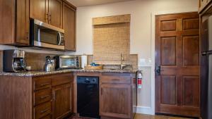 a kitchen with wooden cabinets and a black dishwasher at Park Place by AvantStay in Paso Robles